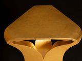 a gold table lamp that is on a black background