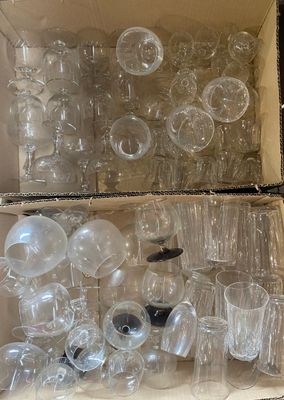 une boîte remplie de verres à vin vides posée par terre