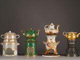 five different colored vases sitting on a table