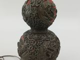 an old lamp with a bird on top of it next to a cord