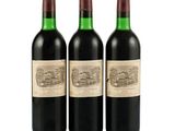 three bottles of red wine sit next to each other on a white surface