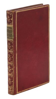 un vieux livre à la couverture rouge et à la bordure dorée