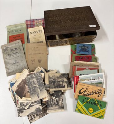 de nombreux livres anciens posés sur une table, à côté d'une boîte en bois