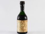 une vieille bouteille de vin posée sur une surface blanche