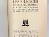 un livre ouvert posé sur une table à côté d'une feuille de papier