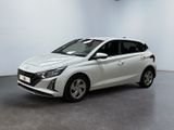 La voiture blanche est garée dans une pièce aux murs blancs.