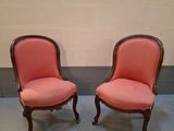 une paire de fauteuils rembourrés roses dans un coin de la pièce