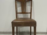 a wooden chair with a leather seat on a tile floor