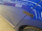 a close up of a blue car with a sticker on it