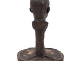 an old wooden sculpture of a man ' s head on a stand