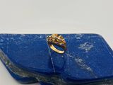 un gros plan d'une bague en or sertie d'une pierre bleue