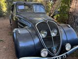 une vieille voiture garée près d'un arbre