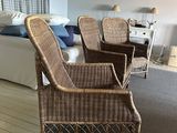 a wicker chair in the middle of a living room