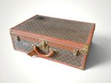 a brown and tan suitcase sitting on a white surface