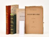 several books are stacked on top of each other on a white surface