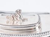 a silver plate with a dog on it on a table