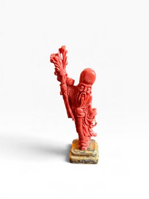 une image représentant une figurine rouge d'un homme tenant une fleur
