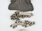 an image of a purse, chain, and ring on a white surface