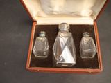 three small glass bottles in a case on a table