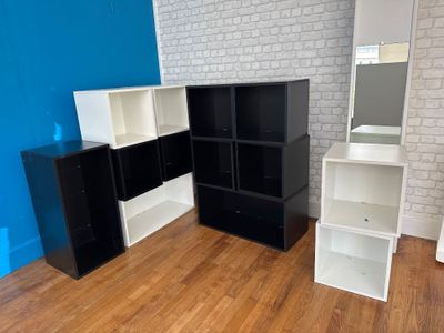 a picture of a room with a white brick wall and a black and white bookcase
