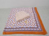 une couverture orange et blanche sur laquelle est posé un bonnet