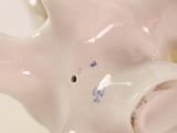 a close up of a white ceramic animal with a hole in it ' s mouth