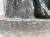 a close up of a statue of a person holding a bird