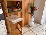 a wooden shelf with books on it in the corner of a room