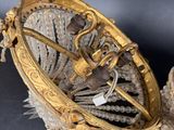 a gold clock with a chain hanging from it ' s side