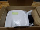 a white toilet in a cardboard box on a wooden floor