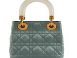 a blue handbag with a white handle on a white background