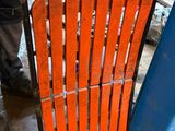 un homme qui se tient debout à côté d'une chaise orange