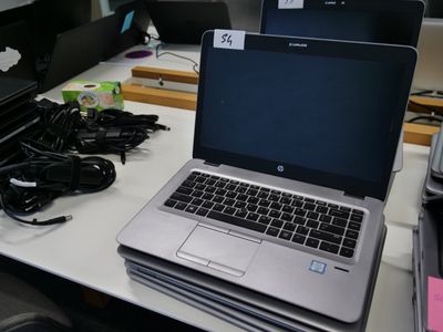 un ordinateur portable posé sur un bureau blanc