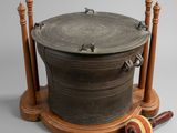 a large metal pot sitting on top of a wooden stand