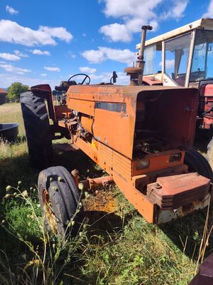 a tractor that is sitting in the grass in the field