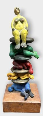 a statue of a man sitting on top of a stack of plates
