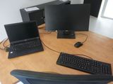 three laptops and a keyboard on a wooden desk