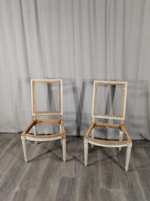 une paire de chaises peintes en blanc, posées contre un rideau, devant un rideau blanc