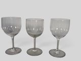 three empty wine glasses sitting next to each other on a table