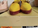 a box with a pair of yellow shoes on top of it