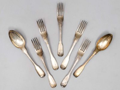 six fourchettes et cuillères sont disposées en cercle sur une table