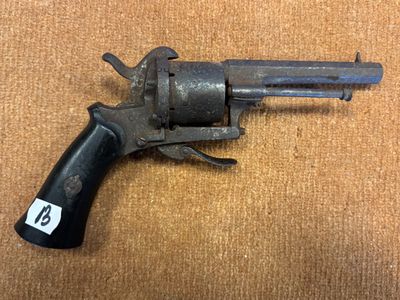 un vieux pistolet avec une étiquette, posé sur une table