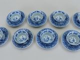 six tasses et soucoupes bleues et blanches posées sur une table