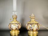 pair of gold and black lamps on a black table with a white background