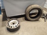 a tire and a wheel on the floor next to a wall