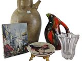 a vase, a plate, and a picture of a woman on a table