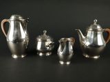un ensemble de théières et de cafetières en argent posées sur un fond noir