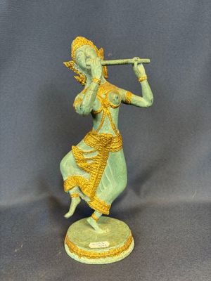 an image of a statue of a woman playing a flute