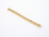 a close up of a gold bracelet on a white surface