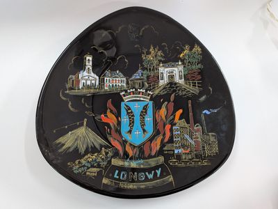 a black plate with a picture of a city on it